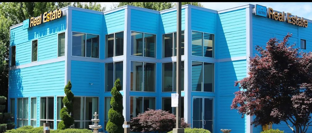 The big blue two-story building with gold &ldquo;Real Estate&rdquo; signs at 20001 SW Tualatin Valley Hwy. Our office is on the second floor.